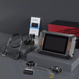 A car diagnostic tool rests on top of a cardboard box, showcasing its compact design and functionality. 