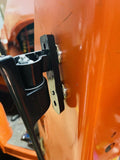 Detailed view of the handle on an orange truck, highlighting its design and the bright color of the vehicle.
